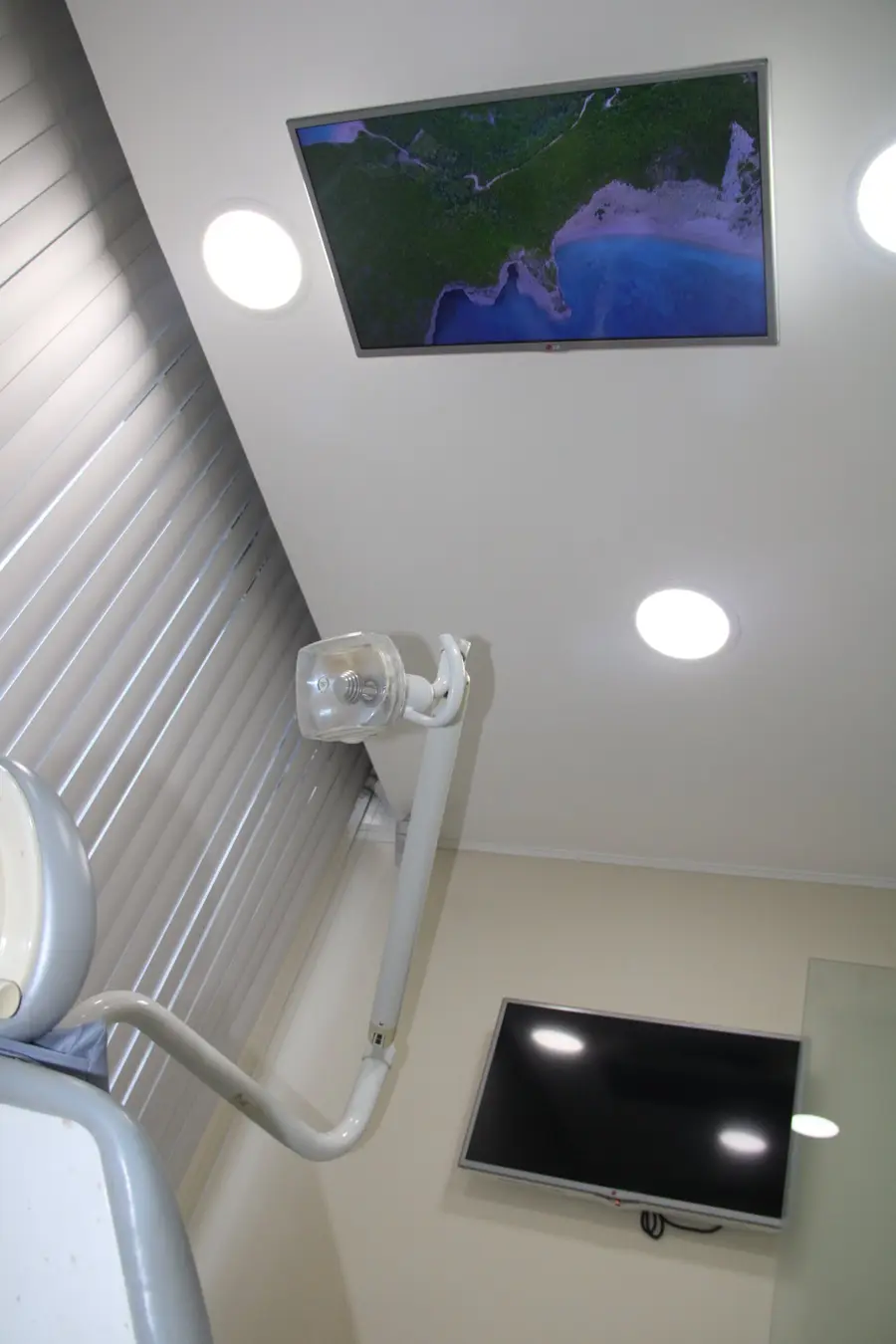 Interior do consultório - visão do paciente na cadeira com TV no teto
